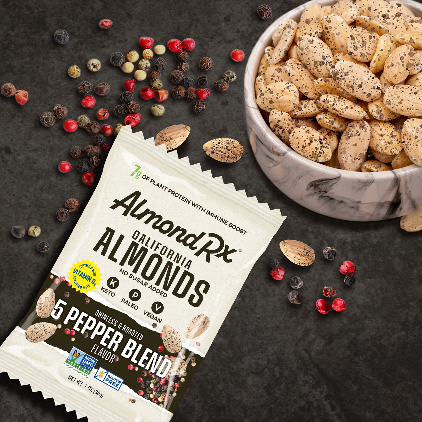 One ounce package of almonds with bowl of almonds and peppercorns.
