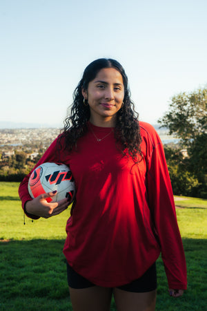 Female soccer player holding soccer ball.