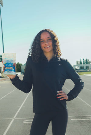 Brinley Campbell, female track star holding high protein snack.