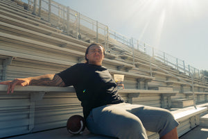 Charlie Pe'a-Shropshire, division 1 football player, sitting on the bleachers.