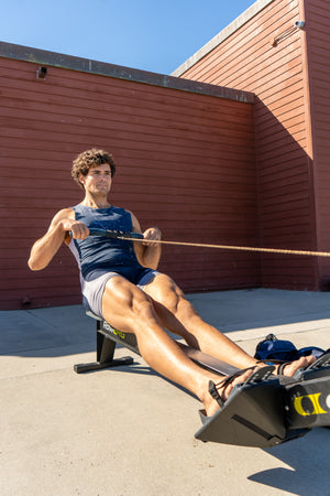 Rex Bales, star of USD rowing team, on an outdoor rowing machine.
