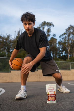 Division 1 basketball player dribbling near bag of almonds.